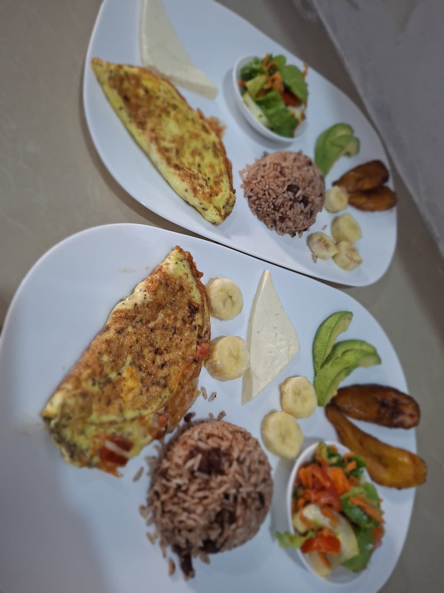 Hearty Costa Rican omelet breakfast with gallo pinto, cheese, avocado and tropical fruit