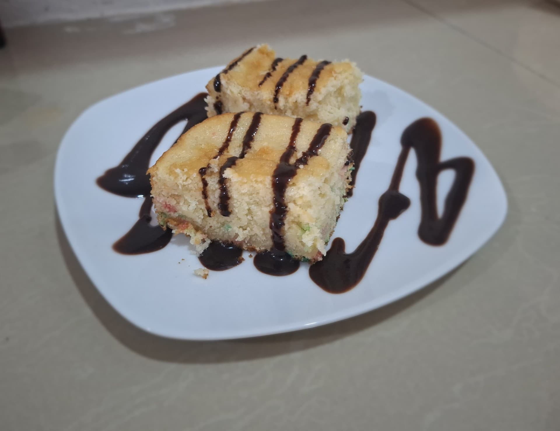 Homemade vanilla cake slices drizzled with chocolate sauce at Hotel Serendipity Tortuguero